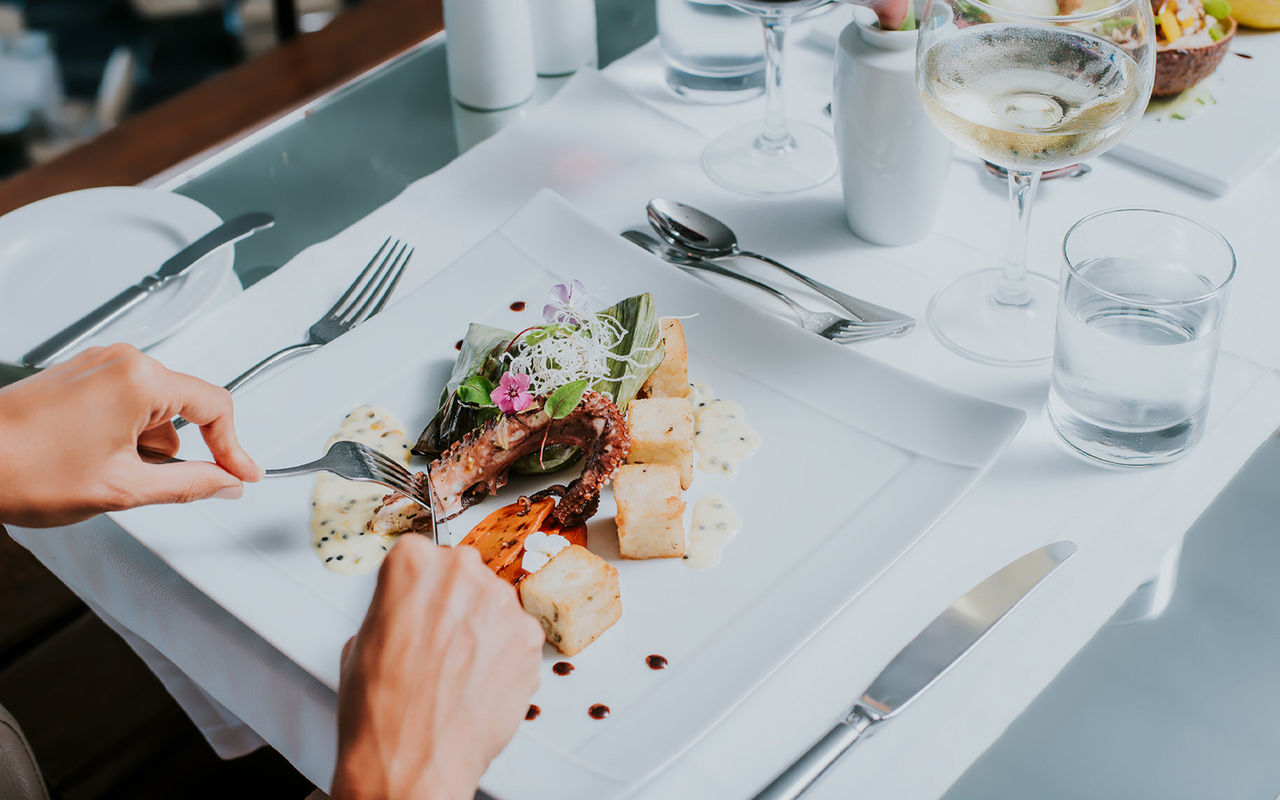 Assiette blanche avec du poulpe et du maïs frit, pendant un repas dans un hôtel de la marque Pestana Hotels and Resorts