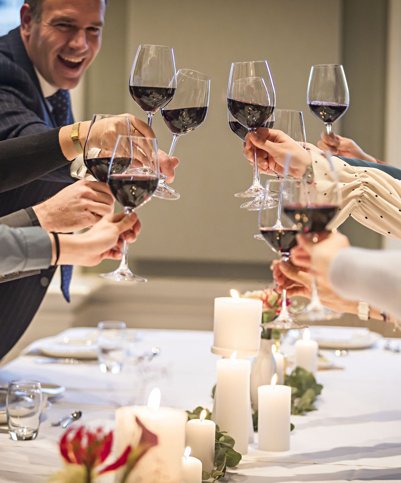 Les invités trinquent avec des verres de vin rouge lors d'un mariage avec une décoration élégante au Pestana Hotel Group