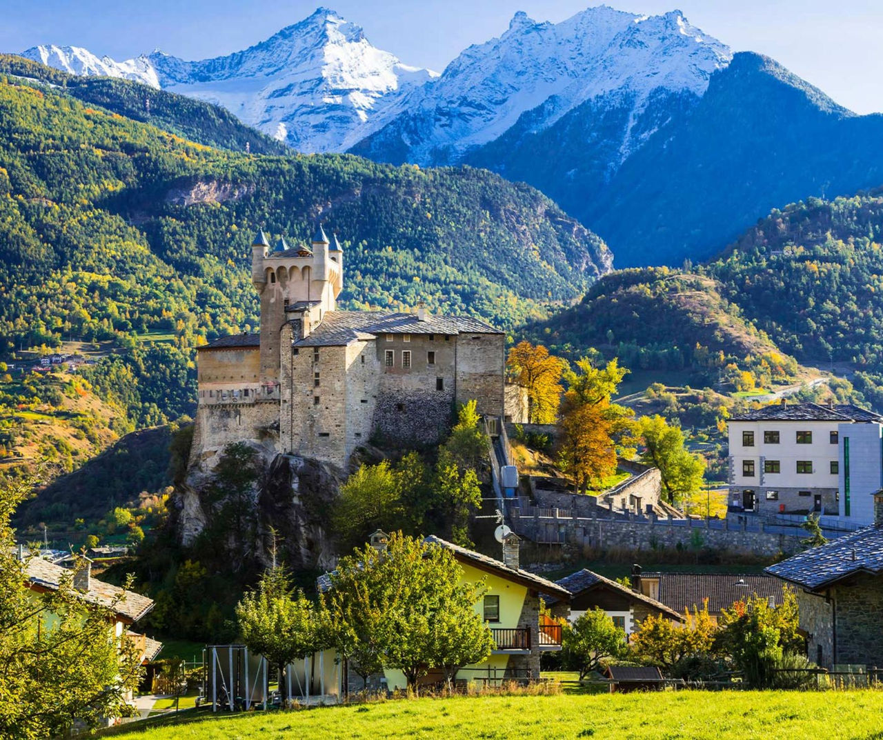 Mountain castle village in Valle d'Aosta with snowy peaks and forested hills featured by Pestana Hotel Group