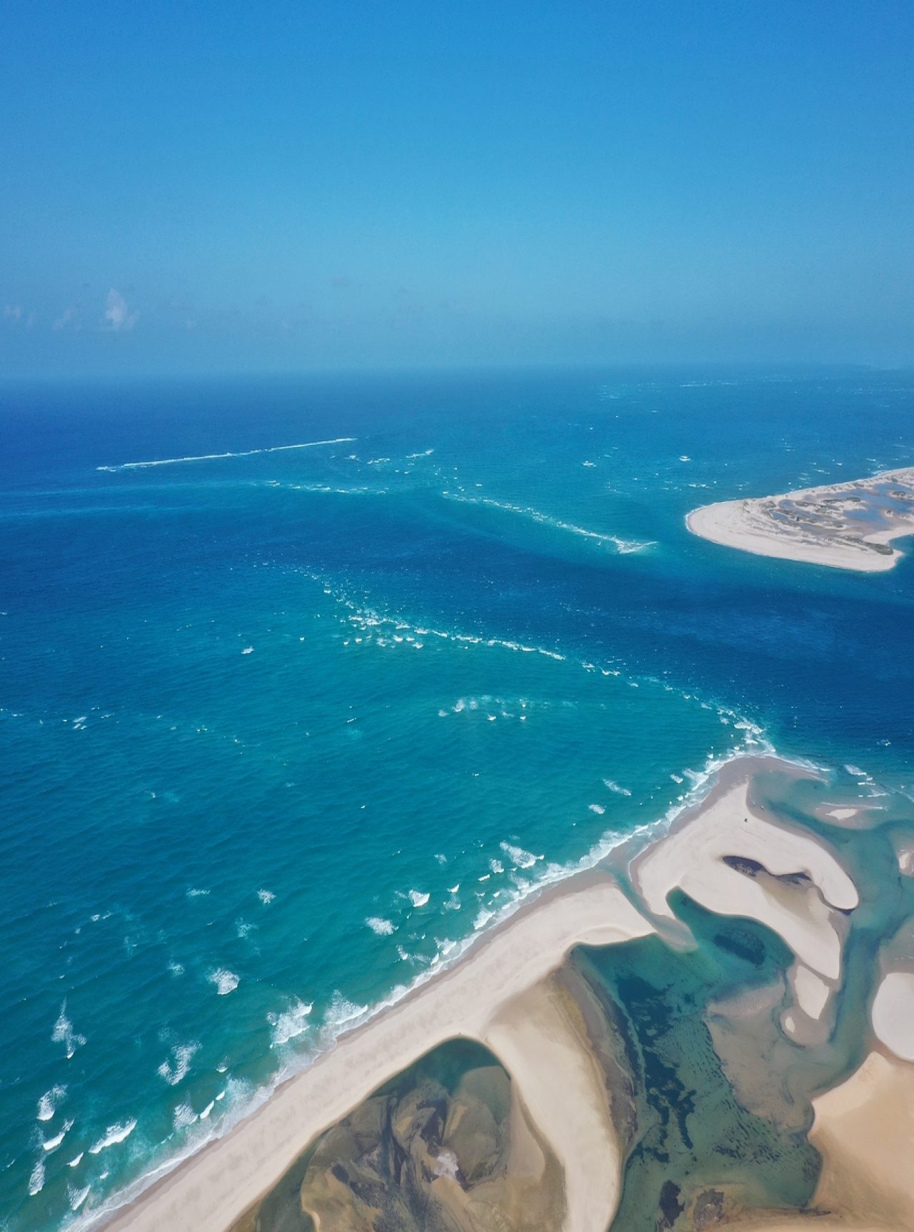 Adembenemend luchtfoto van de baai van Bazaruto, met kristalhelder water, witte zandduinen en koraalriffen