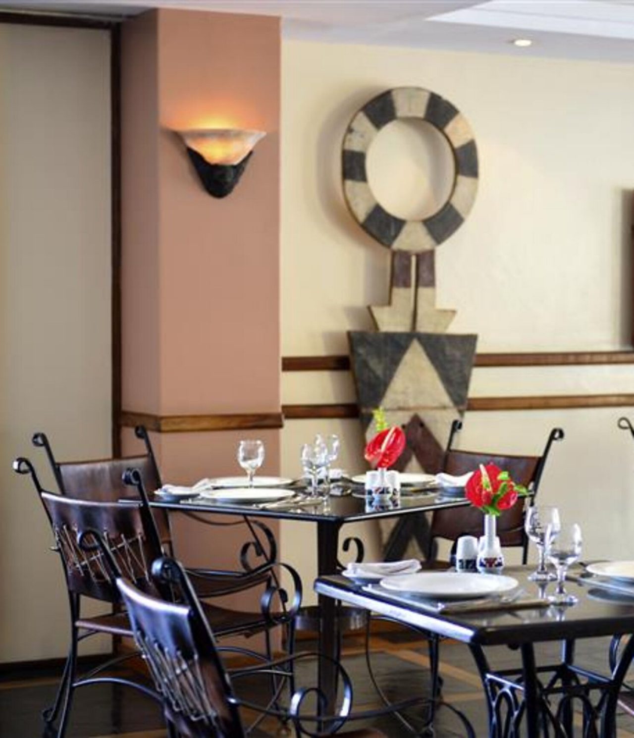 Het restaurant Piazza del Campo, van het 4-sterrenhotel in Maputo, heeft zwarte tafels, stoelen en kunst aan de muren
