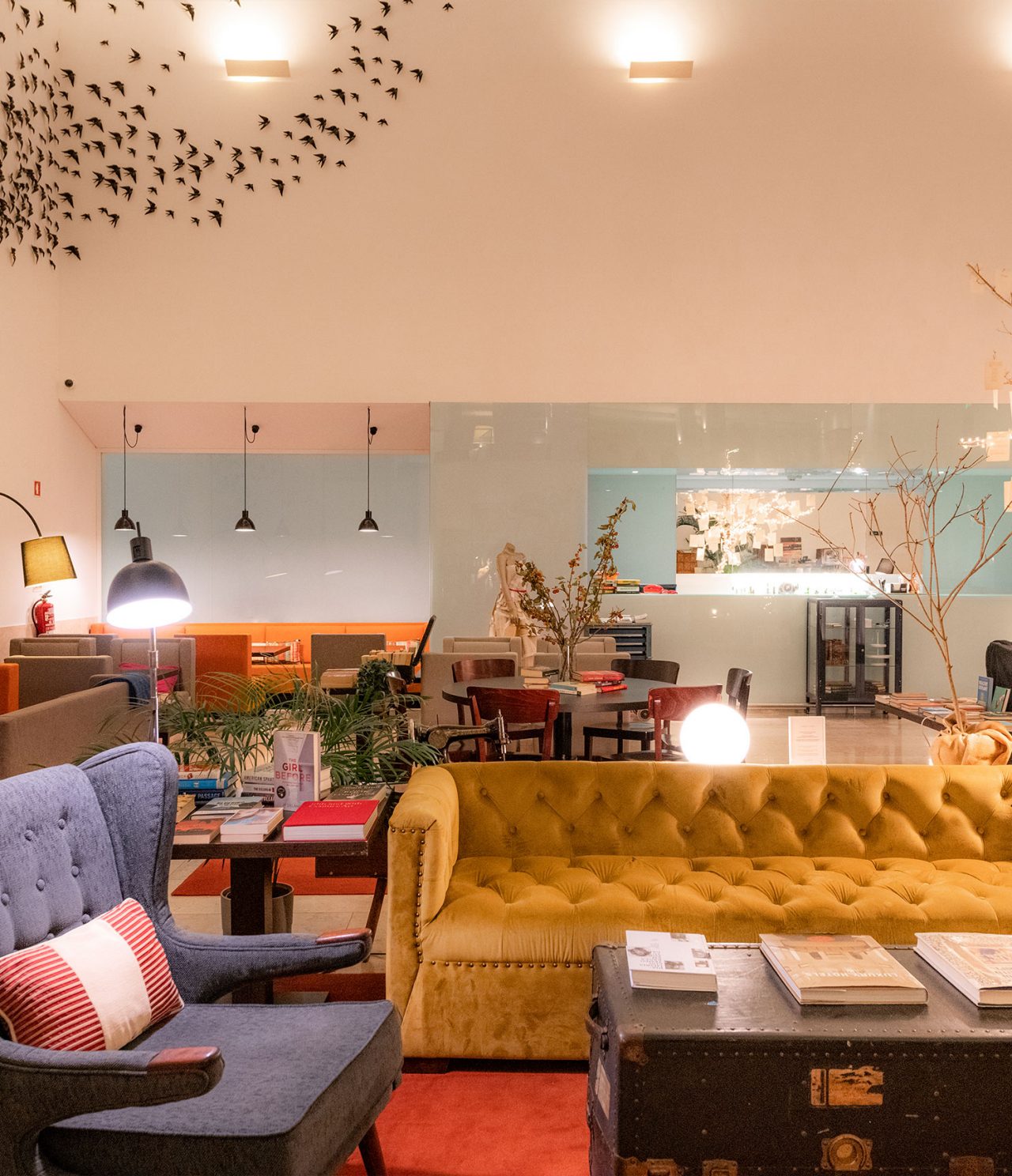 De bar The Chapter, van het 5-sterrenhotel in Cascais, heeft een gele bank, een grijze fauteuil en een tafel