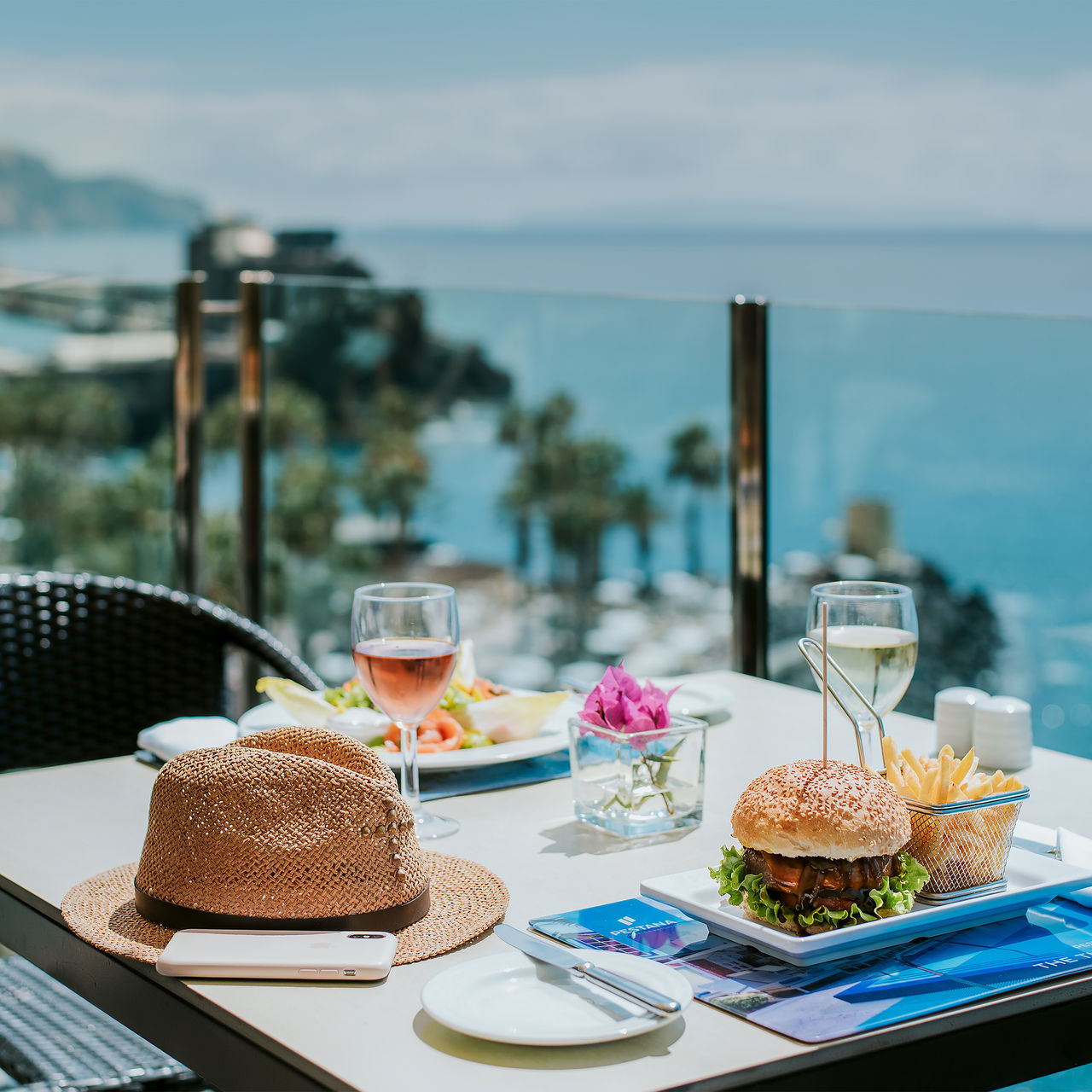 Pestana Madeira Beach Club tafel met zeezicht, hamburgers, friet, wijn en hoed