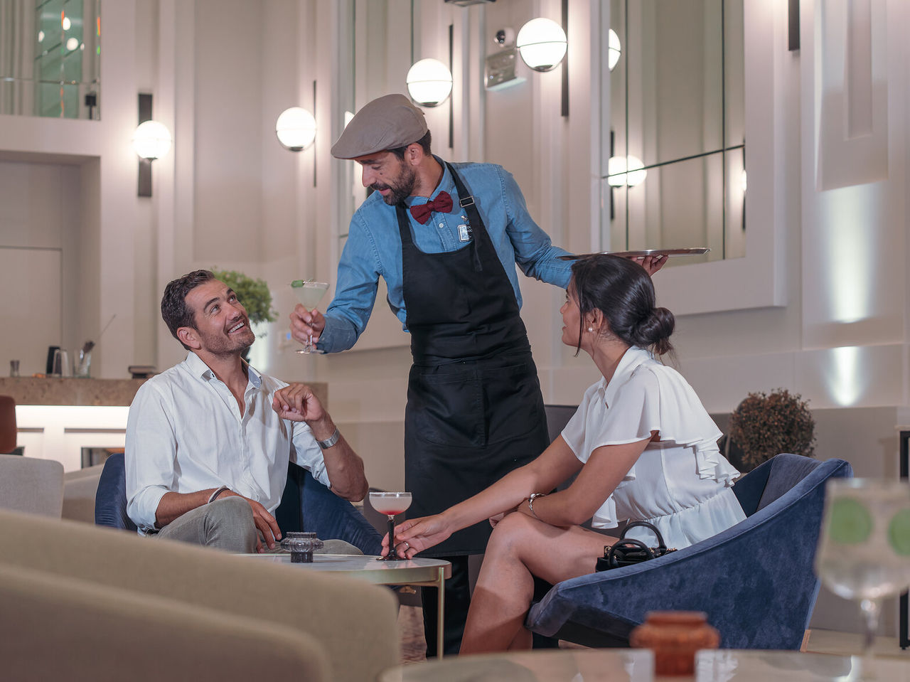 De bar The Great Daisy, van het Premium Hotel in Porto, heeft een binnenbar met stoelen en tafels die cocktails serveert