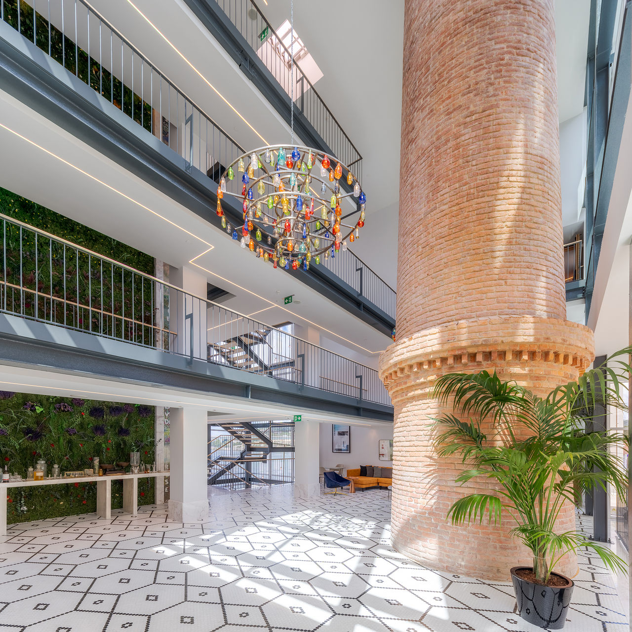 Entreehall Pestana Douro Riverside, met bakstenen schouw en gekleurd glazen kroonluchter