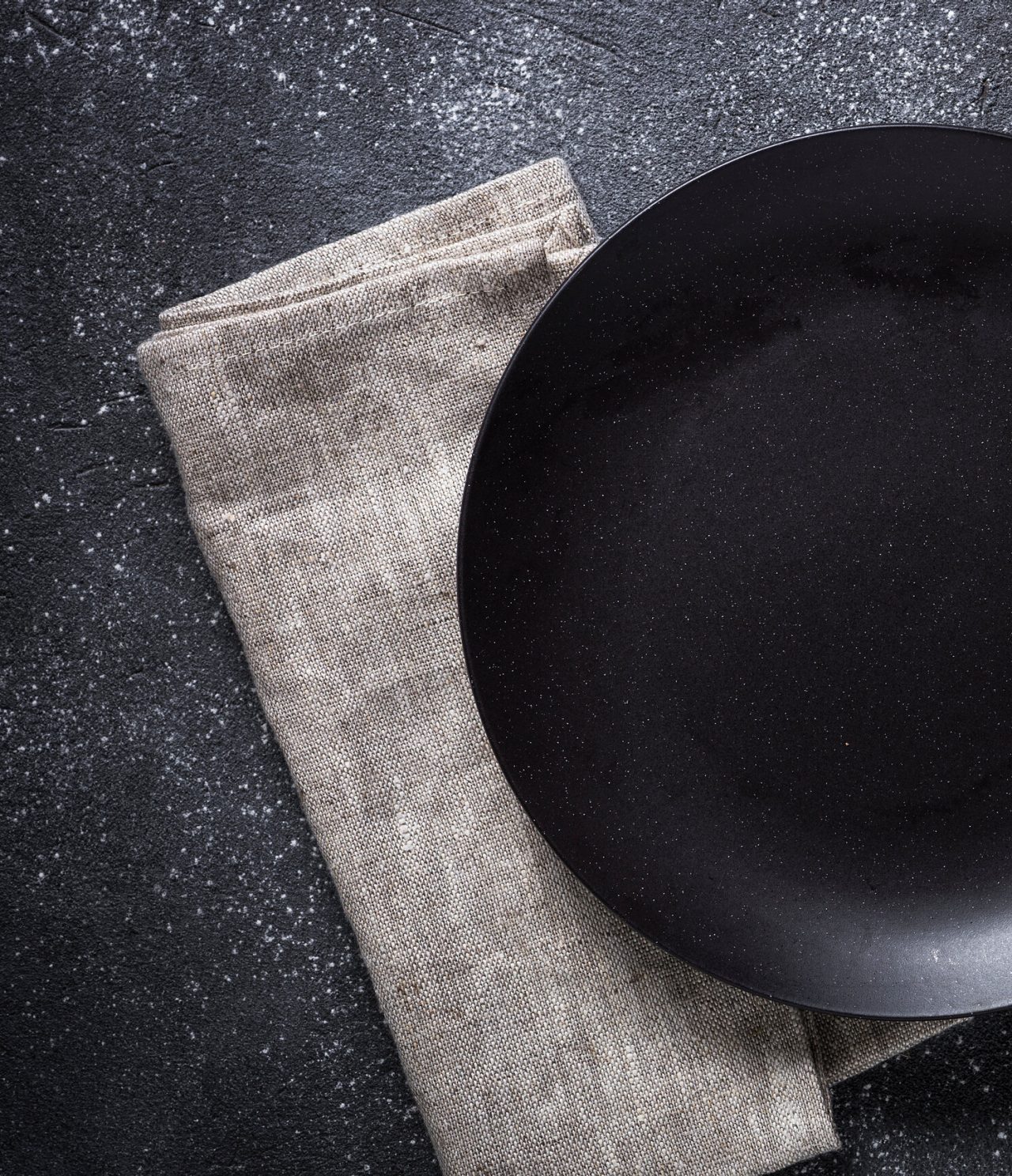 Gerecht voor een gastronomisch diner, mat zwart, geplaatst op een lichtgrijze servet, voor een maaltijd in Buenos Aires