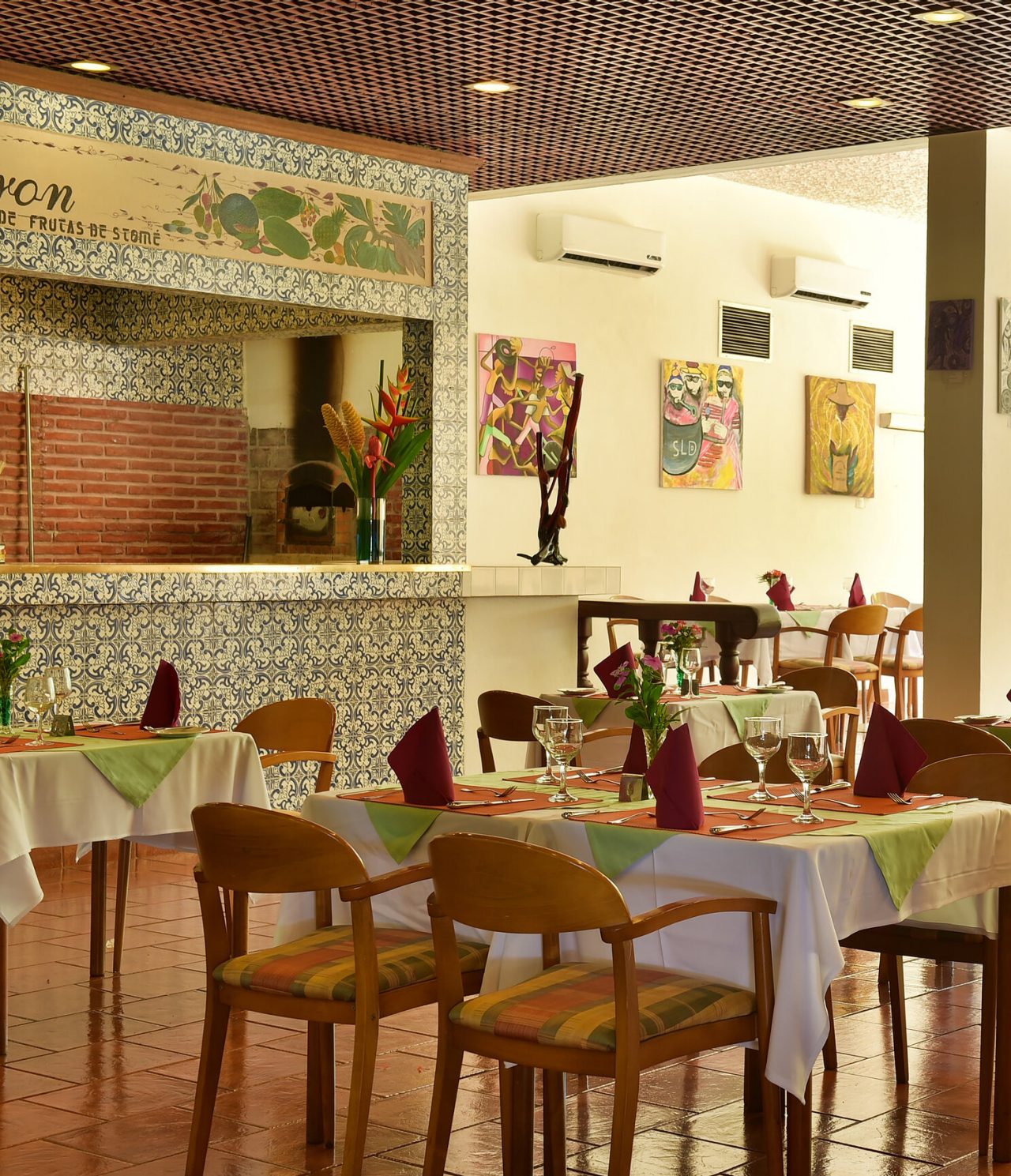 O restaurante Le Baron, do Hotel 4 Estrelas em São Tomé, tem mesas postas com cadeiras de madeira