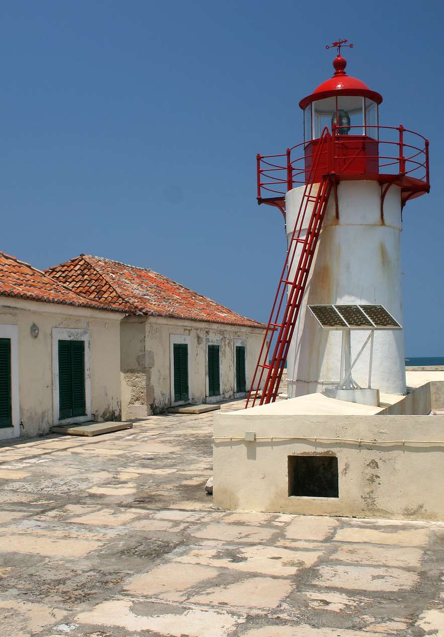 Forte de São Sebastião em São Tomé, onde se pode ver o farol, um canhão e um miradouro com o mar ao fundo