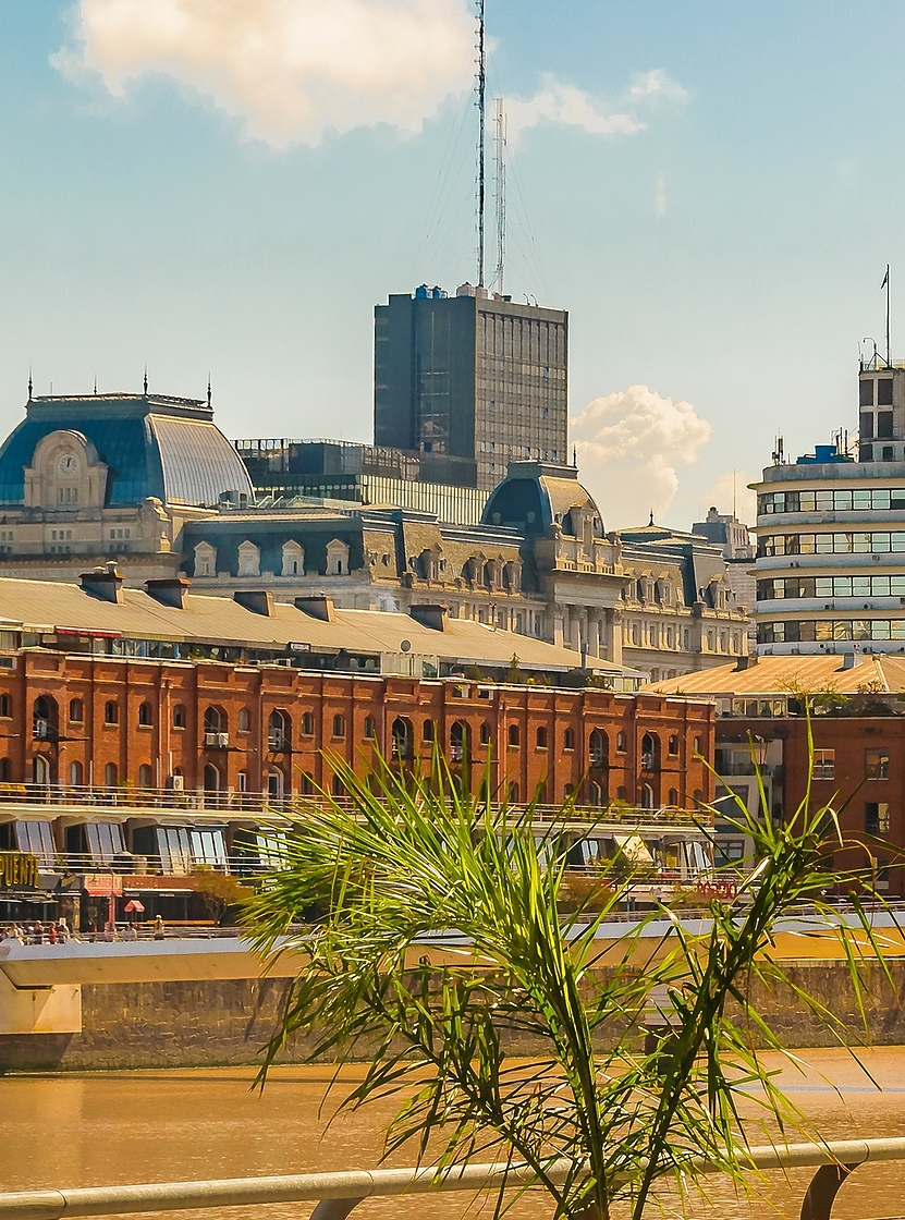 Paisagem urbana de Buenos Aires com o bairro portuário de Puerto Madero, com edifícios altos e um rio Prata