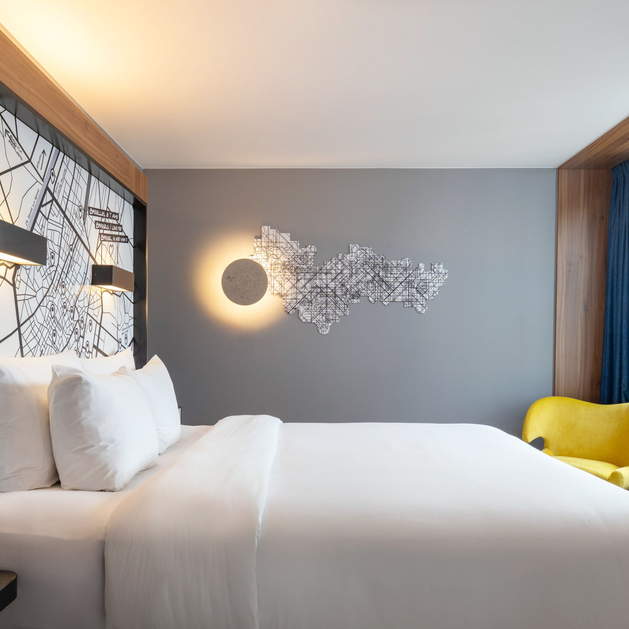 Cama de casal com lençois brancos de um quarto do Pestana Brussels Schuman, um Hotel em Bruxelas, na Bélgica