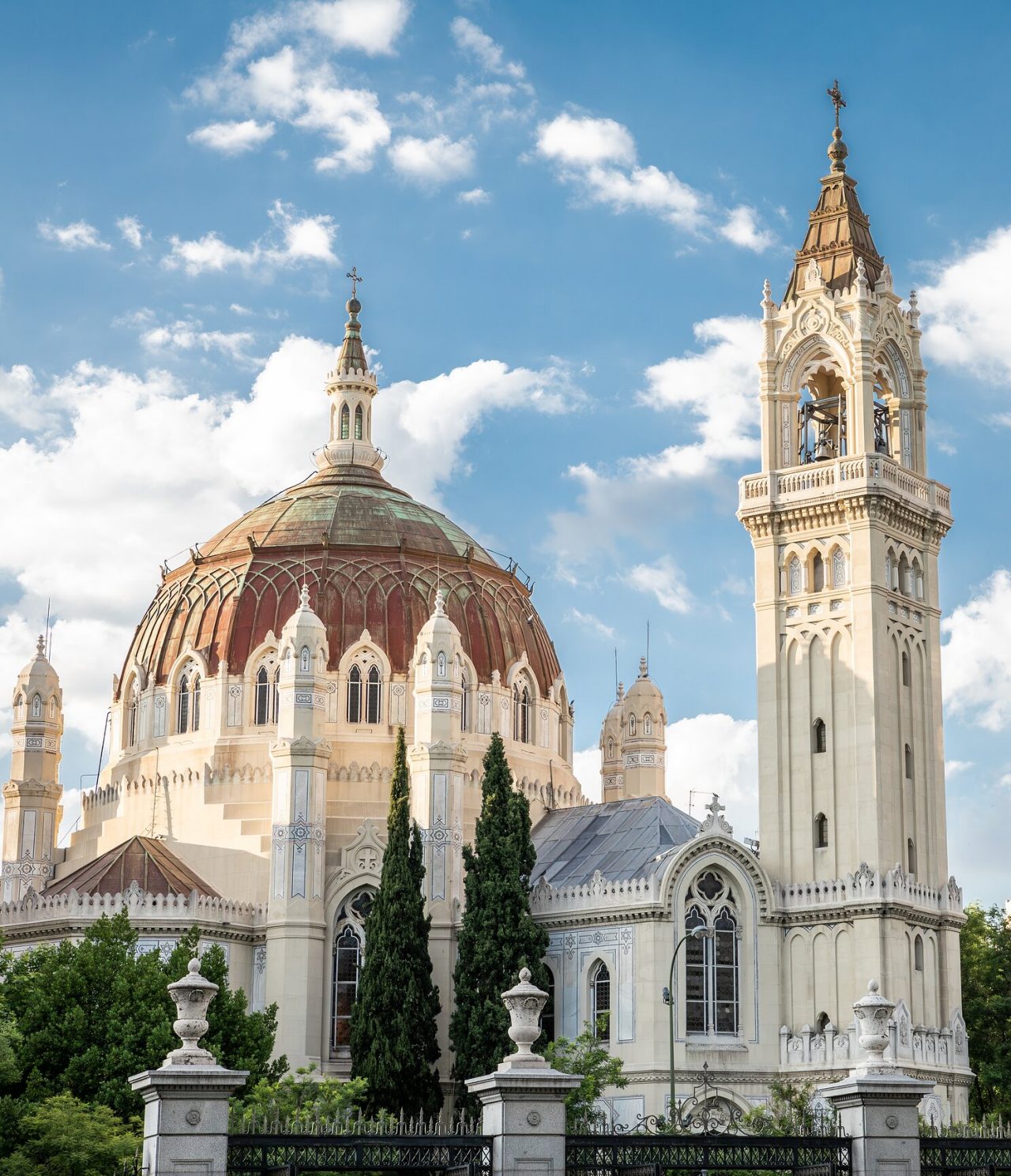 Explore Hotéis em Madrid com vista para uma basílica de cúpula vermelha e torre ornamentada sob céu azul