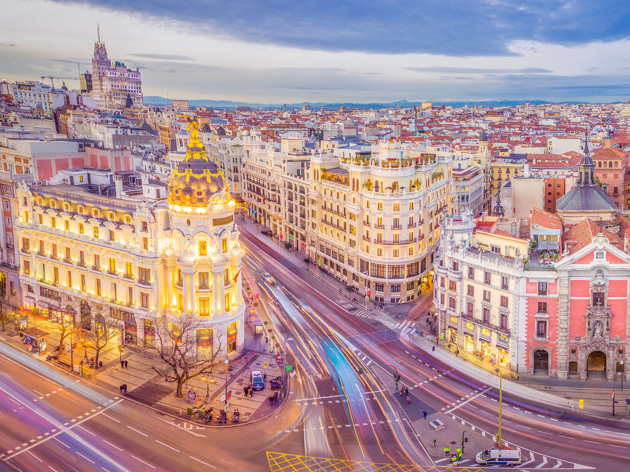 Explore Hotéis em Madrid com vista sobre edifícios iluminados e ruas movimentadas ao entardecer na Gran Vía