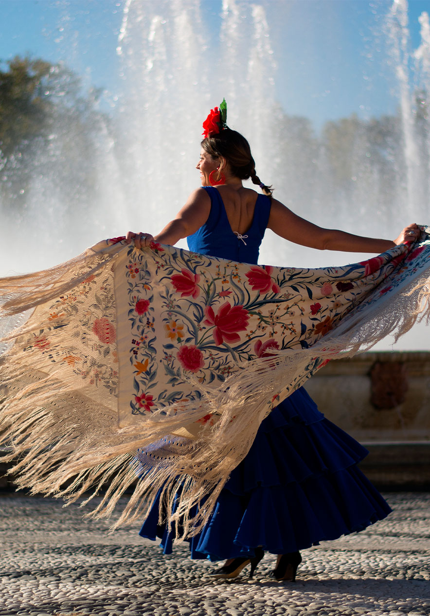 Rapariga a dançar flamenco, em frente a uma fonte com chafaris, em Madrid 