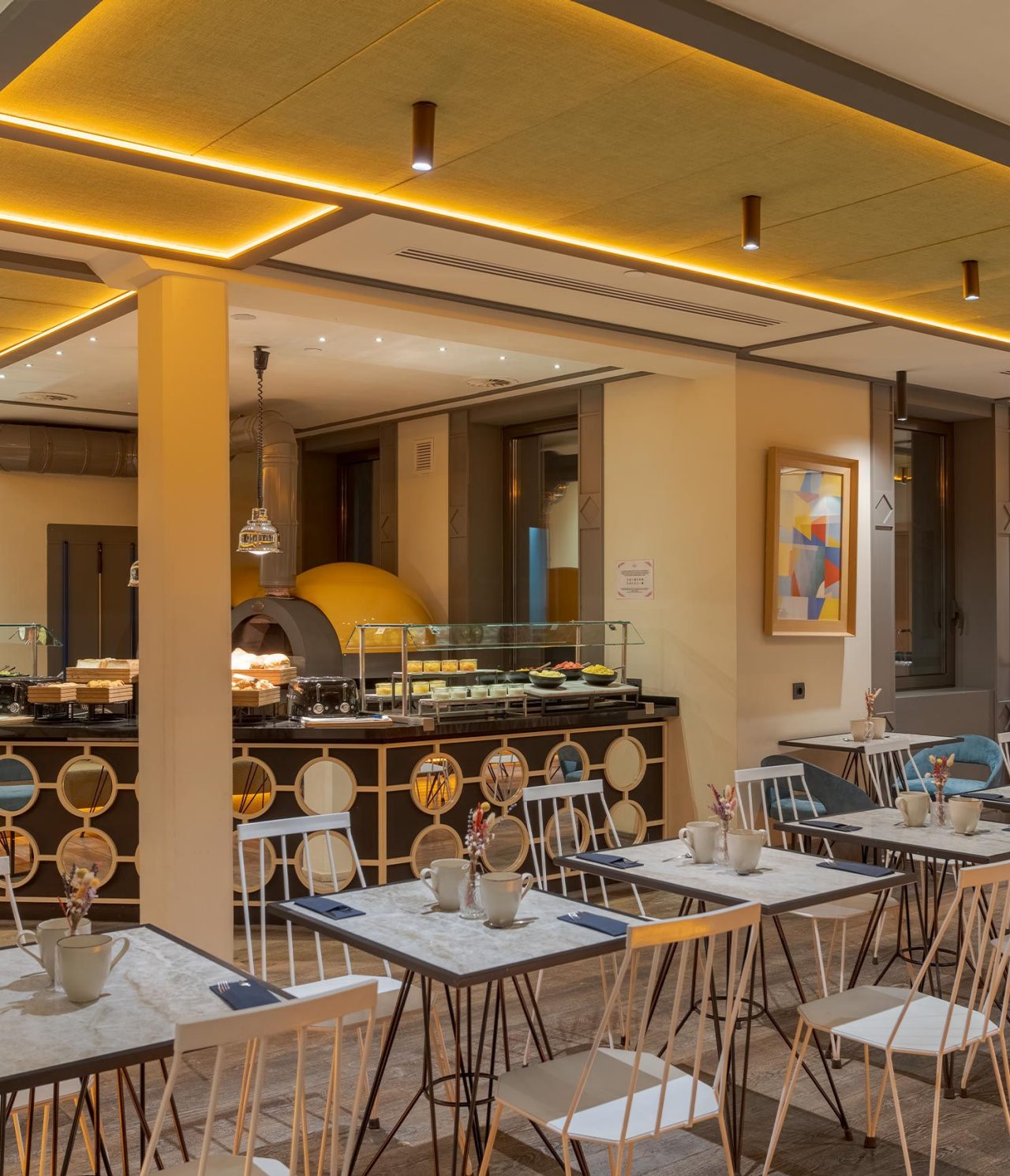 Restaurante do Pestana CR7 Gran Vía Madrid, Hotel no Centro de Madrid, em Espanha com mesas e forno iluminado