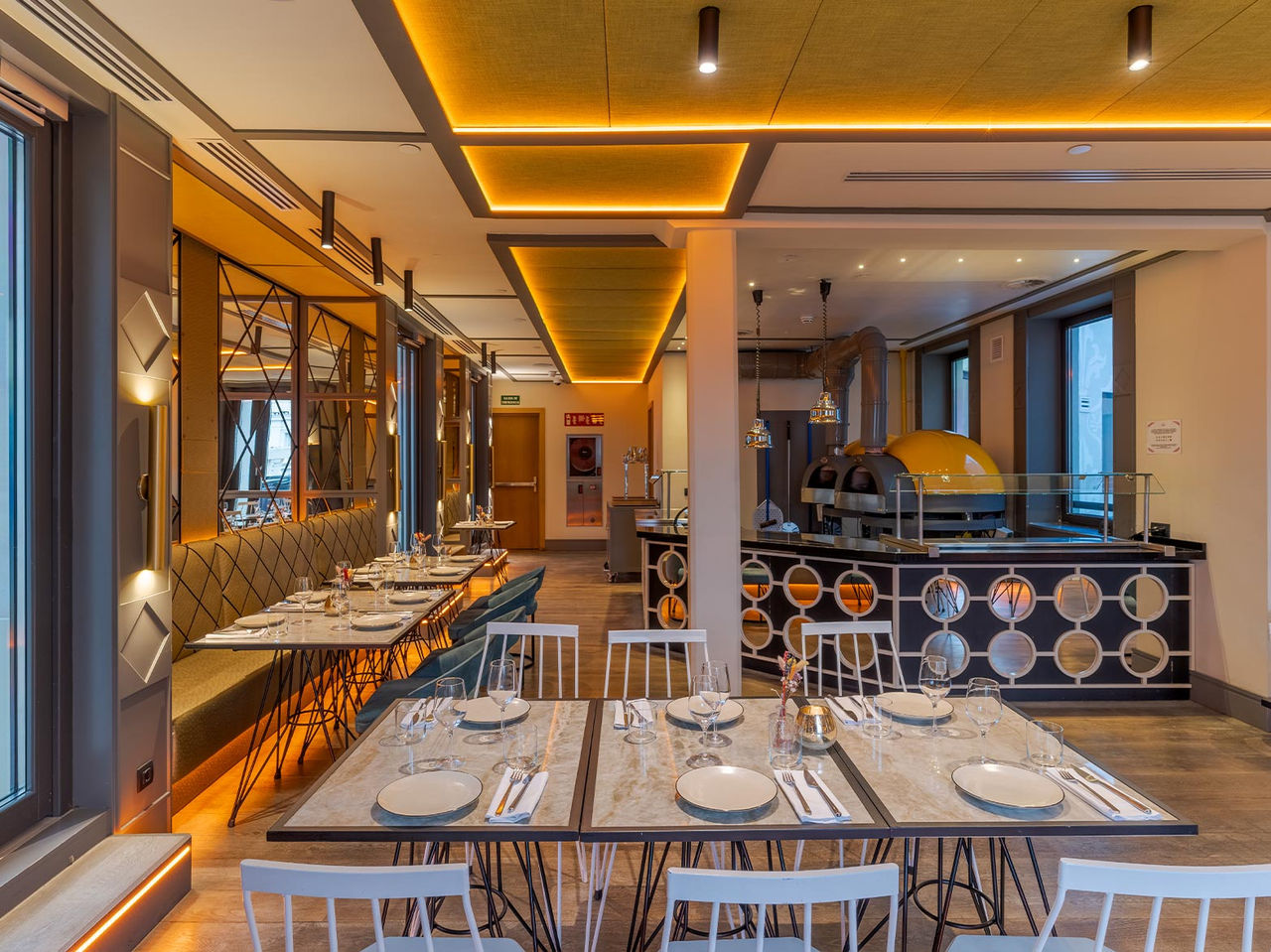 Restaurante do Pestana CR7 Gran Vía Madrid, Hotel no Centro de Madrid, em Espanha com forno de pizza e mesas iluminadas