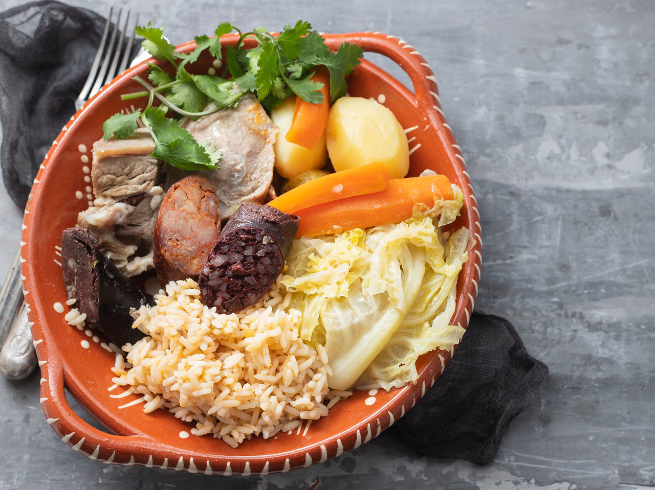Descubra a gastronomia típica dos Açores, com enchidos, legumes e arroz em prato tradicional português