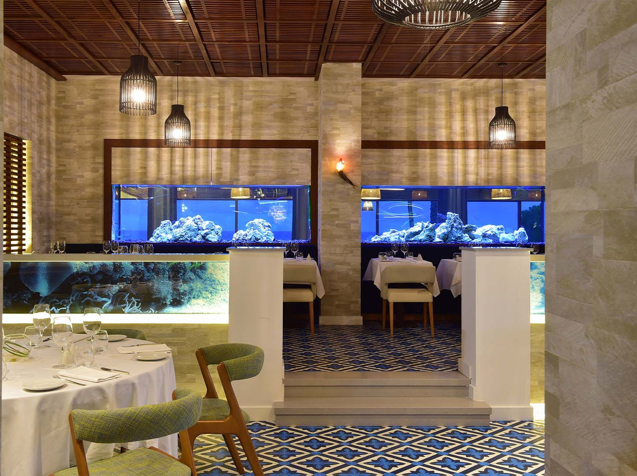 O restaurante Sul, do Hotel 5 Estrelas no Algarve, com aquários, candeeiros de teto e cadeiras almofadadas
