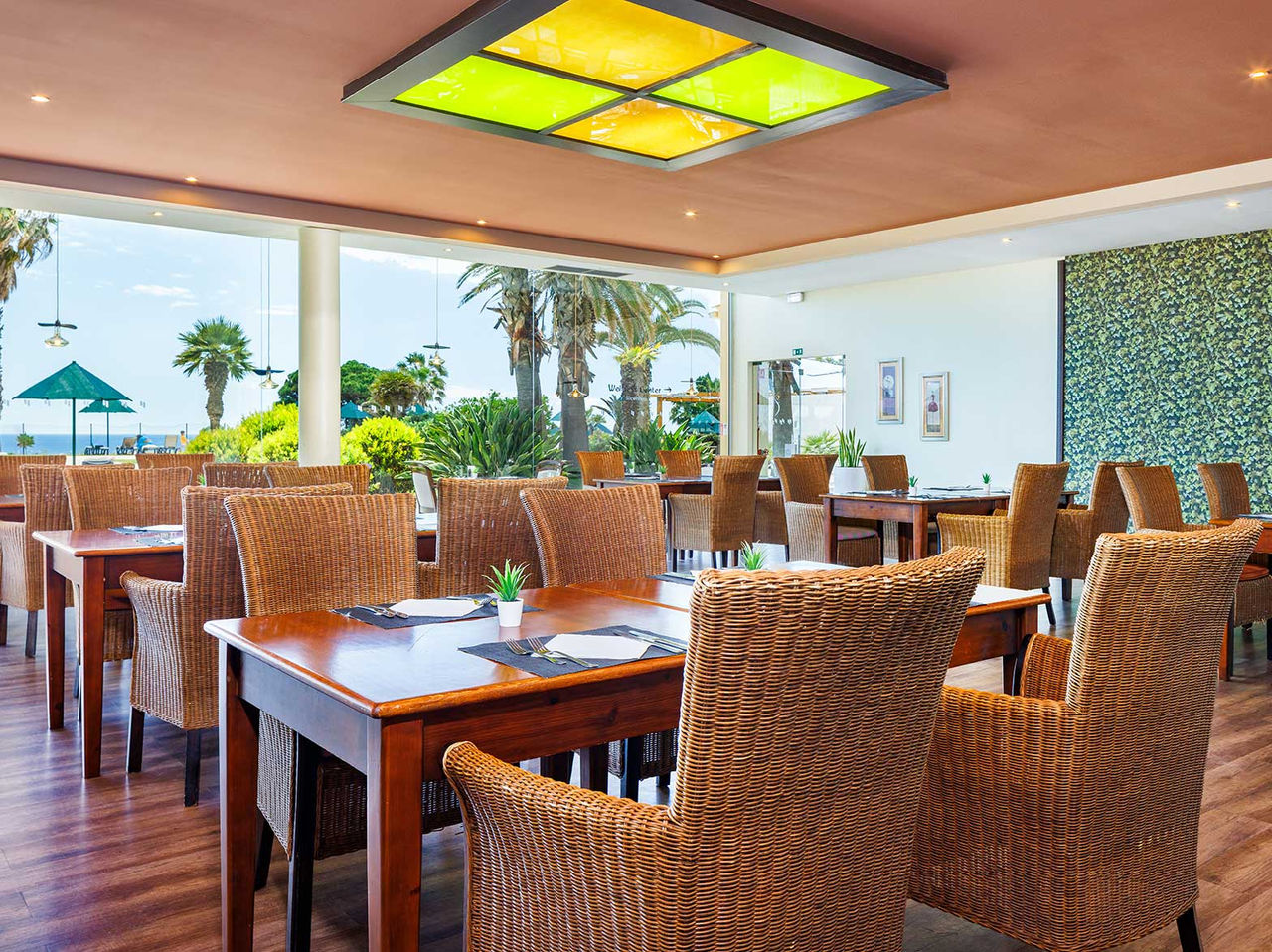 Restaurante do Pestana Viking Hotel com Piscina em Armação de Pêra, com mesas e vista para palmeiras