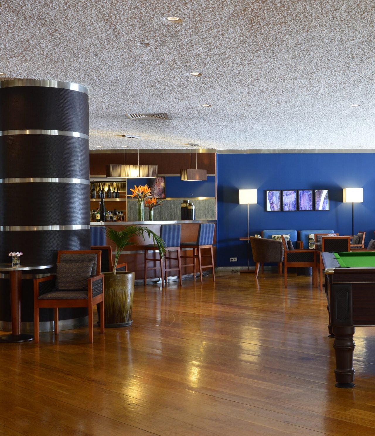 Bar do Pestana Vila Sol, Hotel com Golfe e Spa no Algarve, com balcão elegante, mesas de madeira e decoração moderna em tons de azul