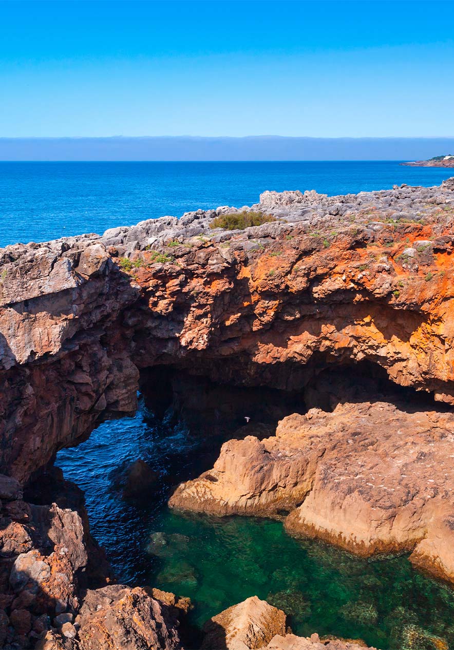 Mar azul encontra-se com rochas imponentes e cria um contraste entre a serenidade da água e a robustez das rochas