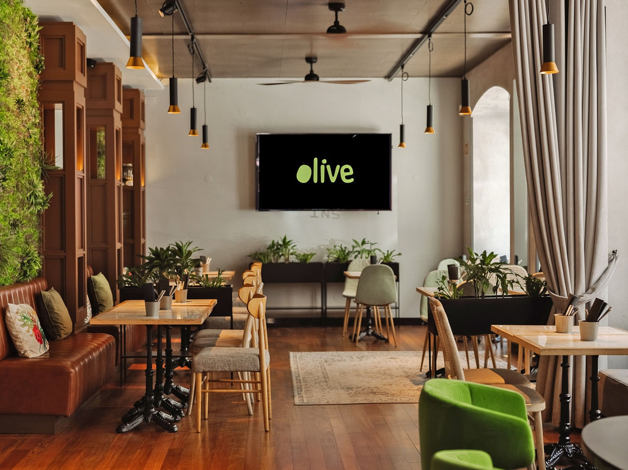 Restaurante do Pestana CR7 Lisboa, Hotel no Centro Histórico de Lisboa, com mesas modernas e parede verde