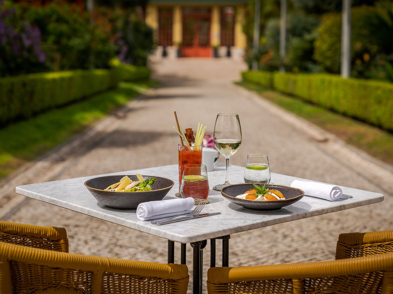 O restaurante Casa do Lago, do Hotel 5 Estrelas, Monumento Nacional, com uma mesa posta, dois pratos e bebidas a acompanhar