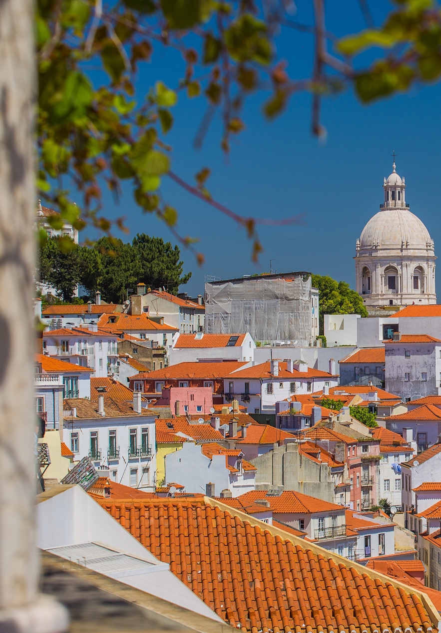 Bairro de Alfama em Lisboa, com vários edifícios coloridos de várias alturas e estilos, evidenciando a história da cidade