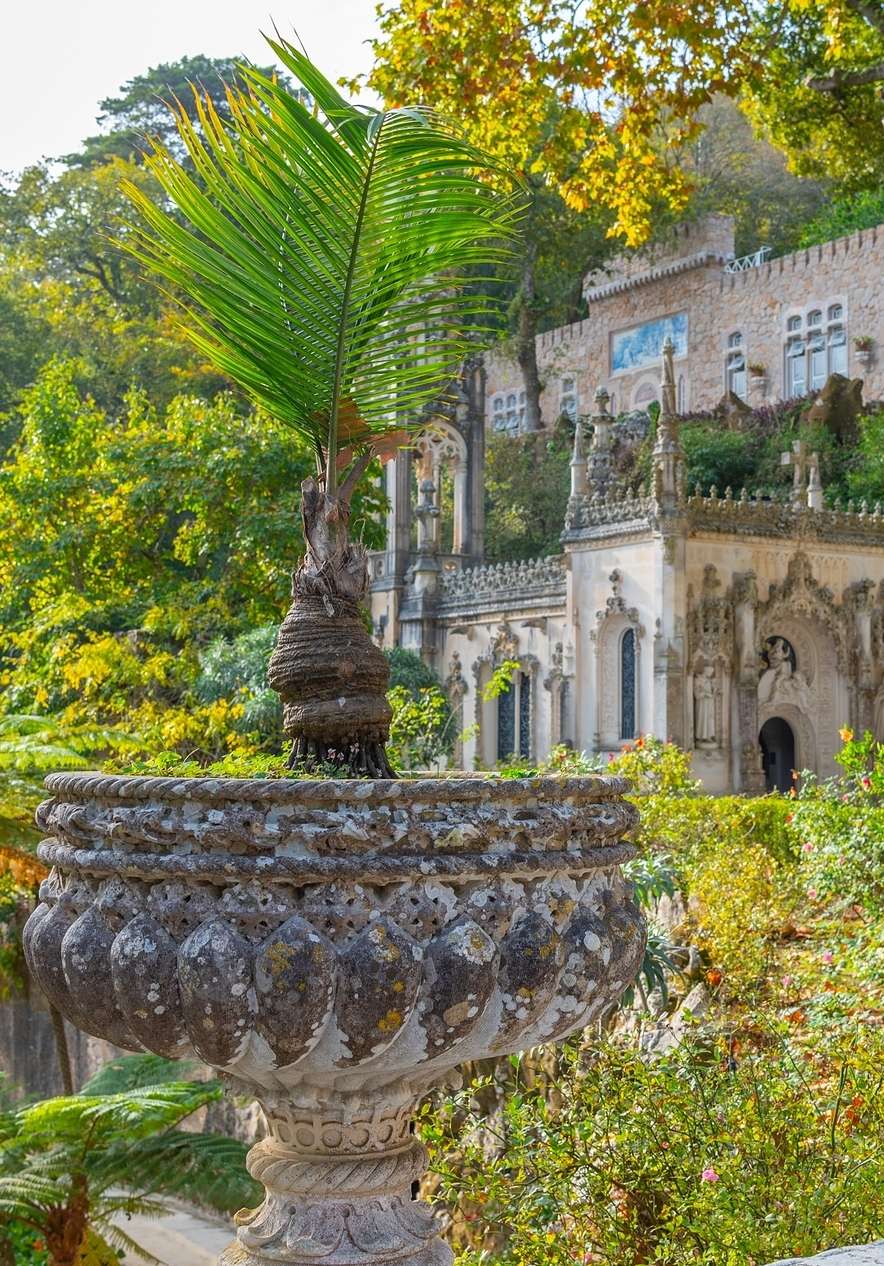 Quinta da Regaleira em Sintra, com fachada adornada de elementos góticos e românticos, rodeada pela intensa vegetação verde