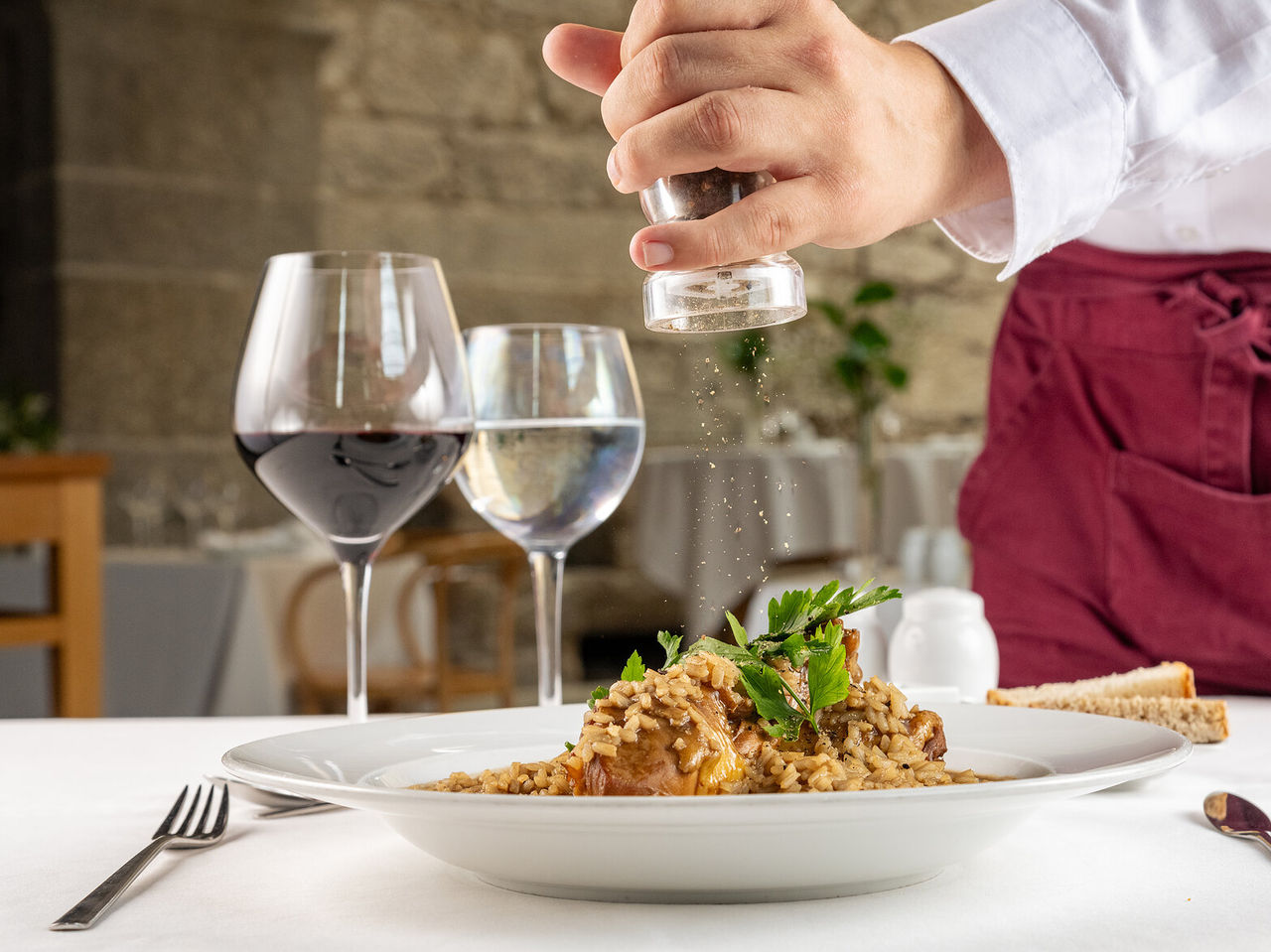Explore Hotéis Históricos de 4 estrelas apresentando prato de arroz servido com vinho numa mesa e taças