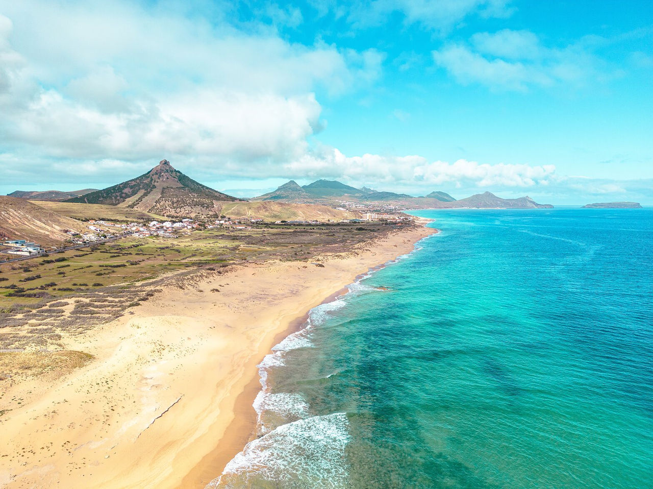 Explore Hotéis em Porto Santo com vista aérea sobre a costa dourada, mar turquesa e montanhas vulcânicas