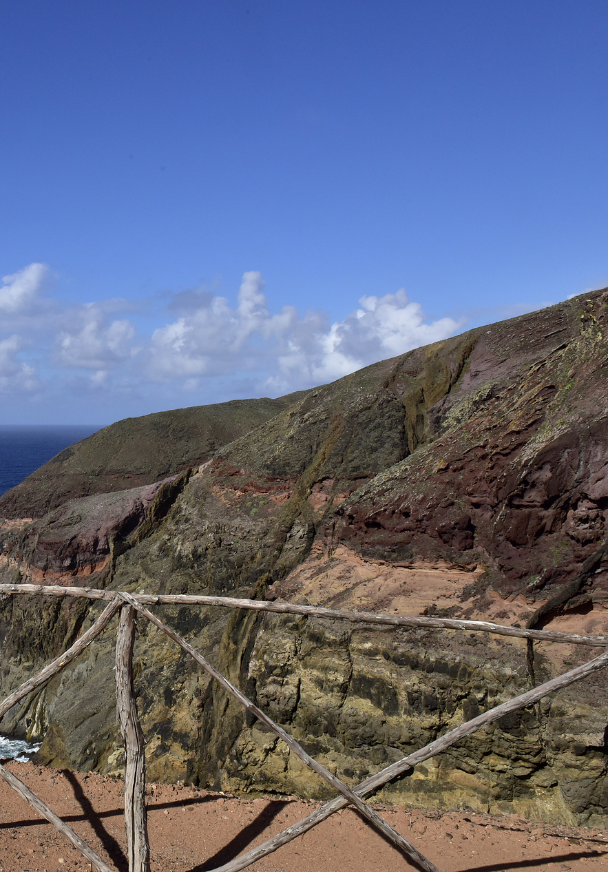 Casal a carregar tacos de golfe, num campo de golfe na ilha do Porto Santo, com céu azul