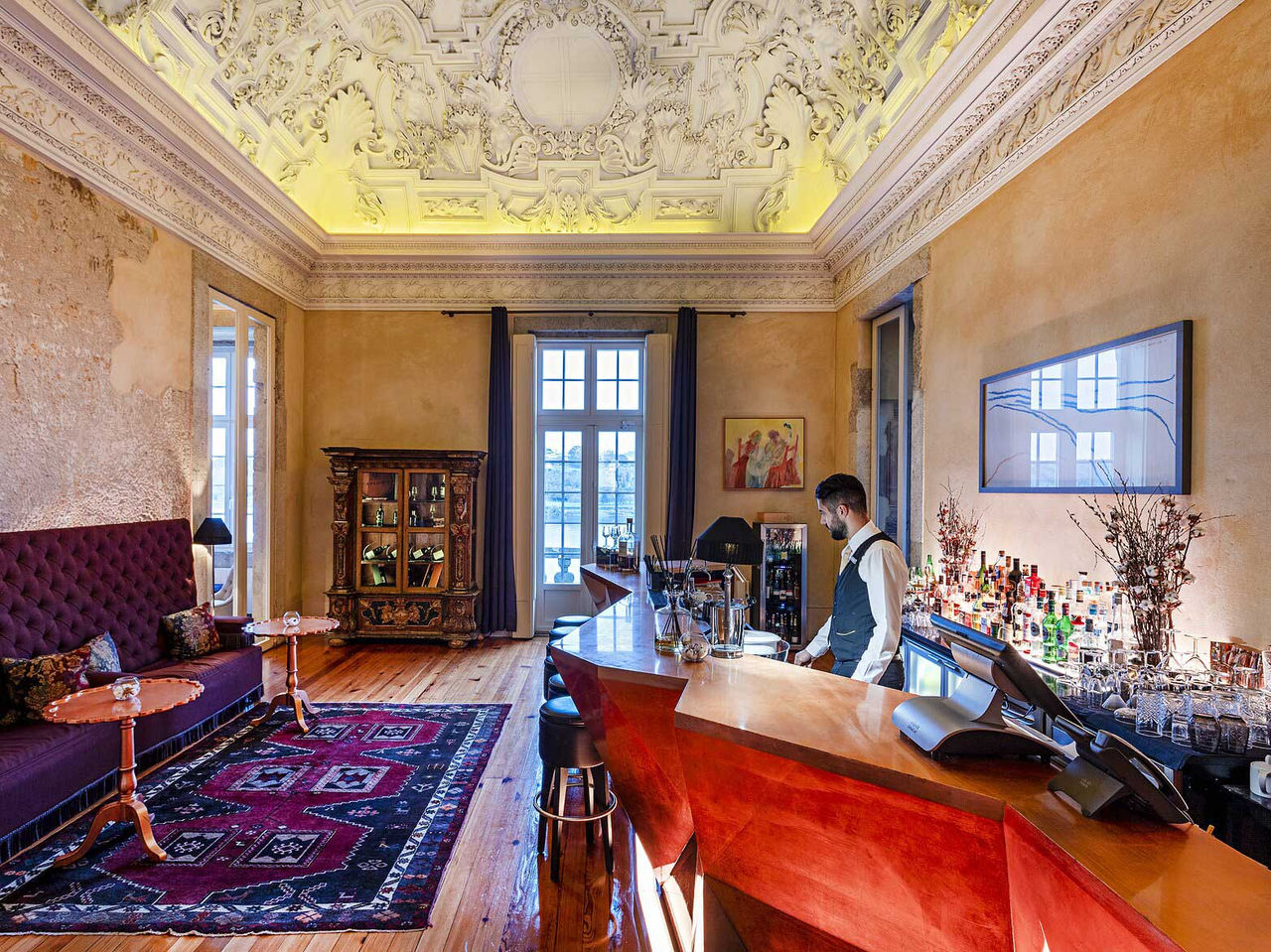 Bar do Pestana Palácio do Freixo, Hotel 5 Estrelas no Porto, Monumento Nacional, com balcão em madeira polida, teto ornamentado e luz natural entrando pelas janelas altas