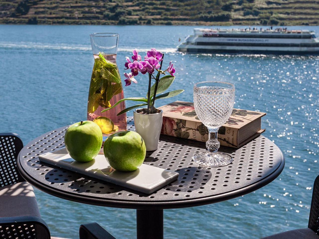 Bar do Pestana Douro Riverside, Hotel Premium no Porto, com mesa junto ao rio com maçãs e bebida fresca
