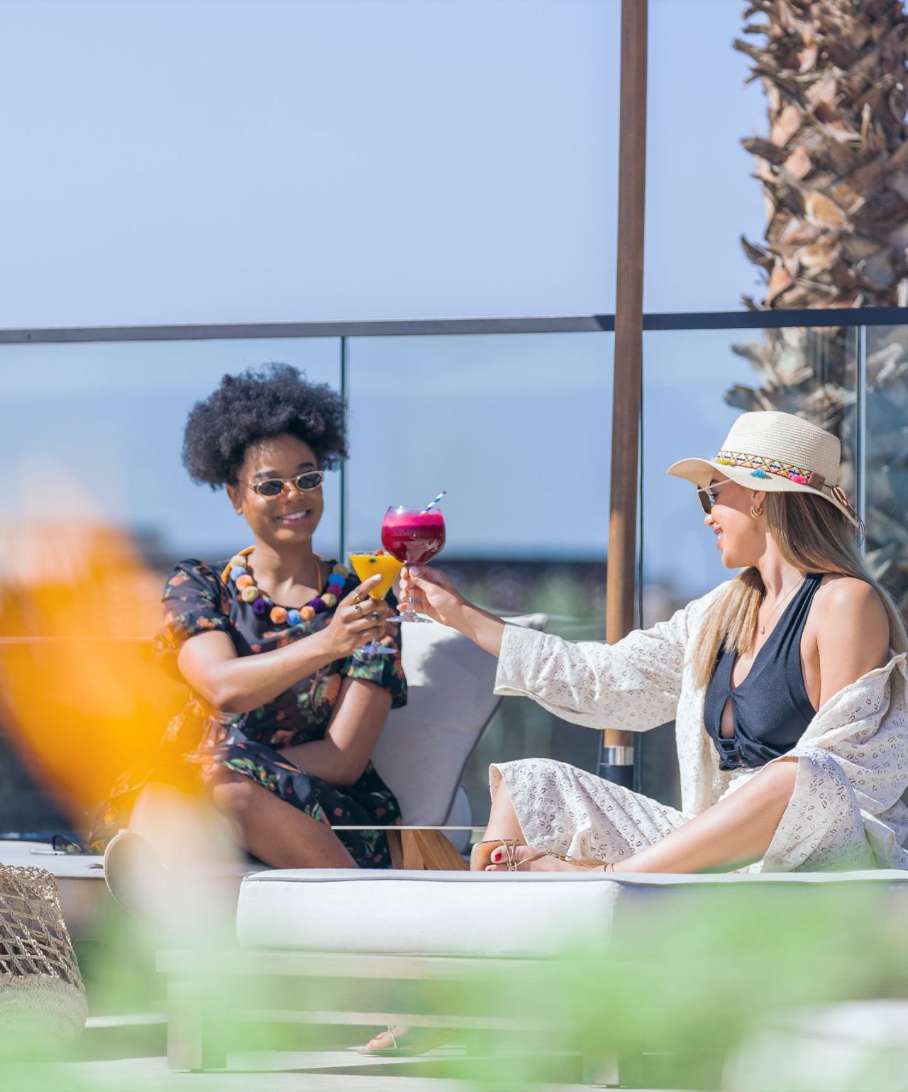 Explore a marca Pestana CR7 Lifestyle Hotels com duas pessoas brindando com cocktails junto à piscina