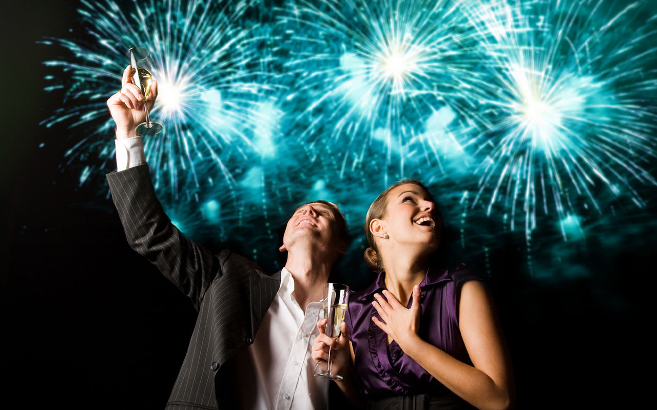 Casal celebra o início do novo ano, com fogo de artificio azul por trás, numa festa de um hotel do Pestana Hotel Group