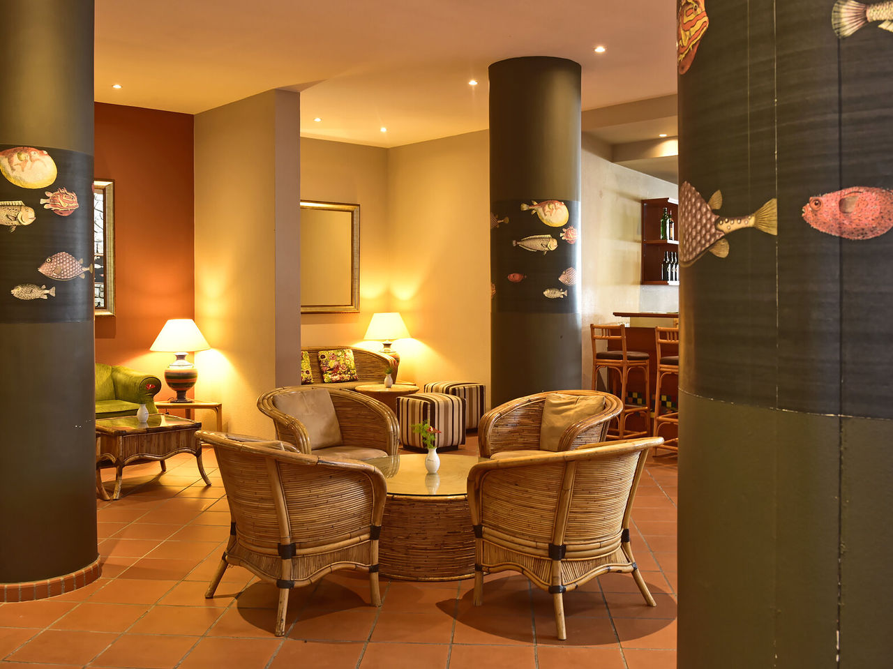 The Arlequim Bar at a 5-Star Hotel in Funchal has bamboo chairs and fish portraits on columns