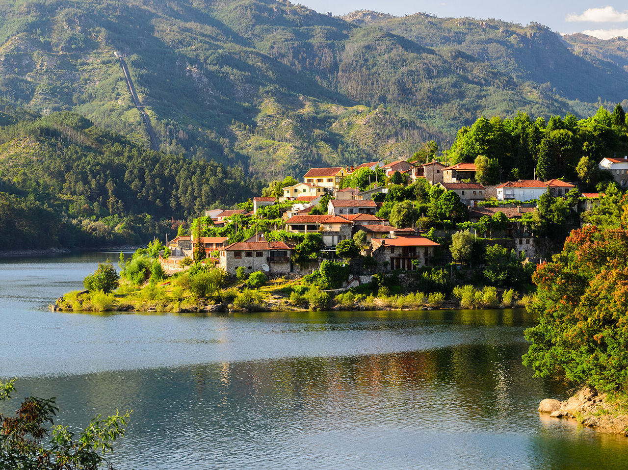 Small village with red roofs by the Douro River, surrounded by a green landscape