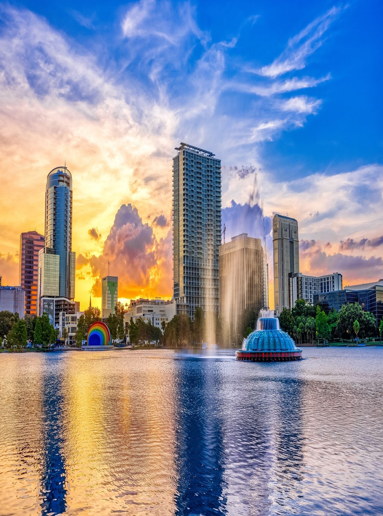 Urban landscape of Orlando at sunset, with a lake and a fountain in the foreground